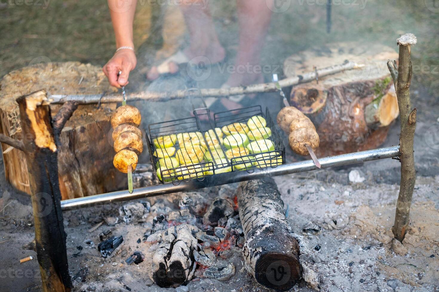 Zucchini and mushrooms are fried on a fire in the forest photo