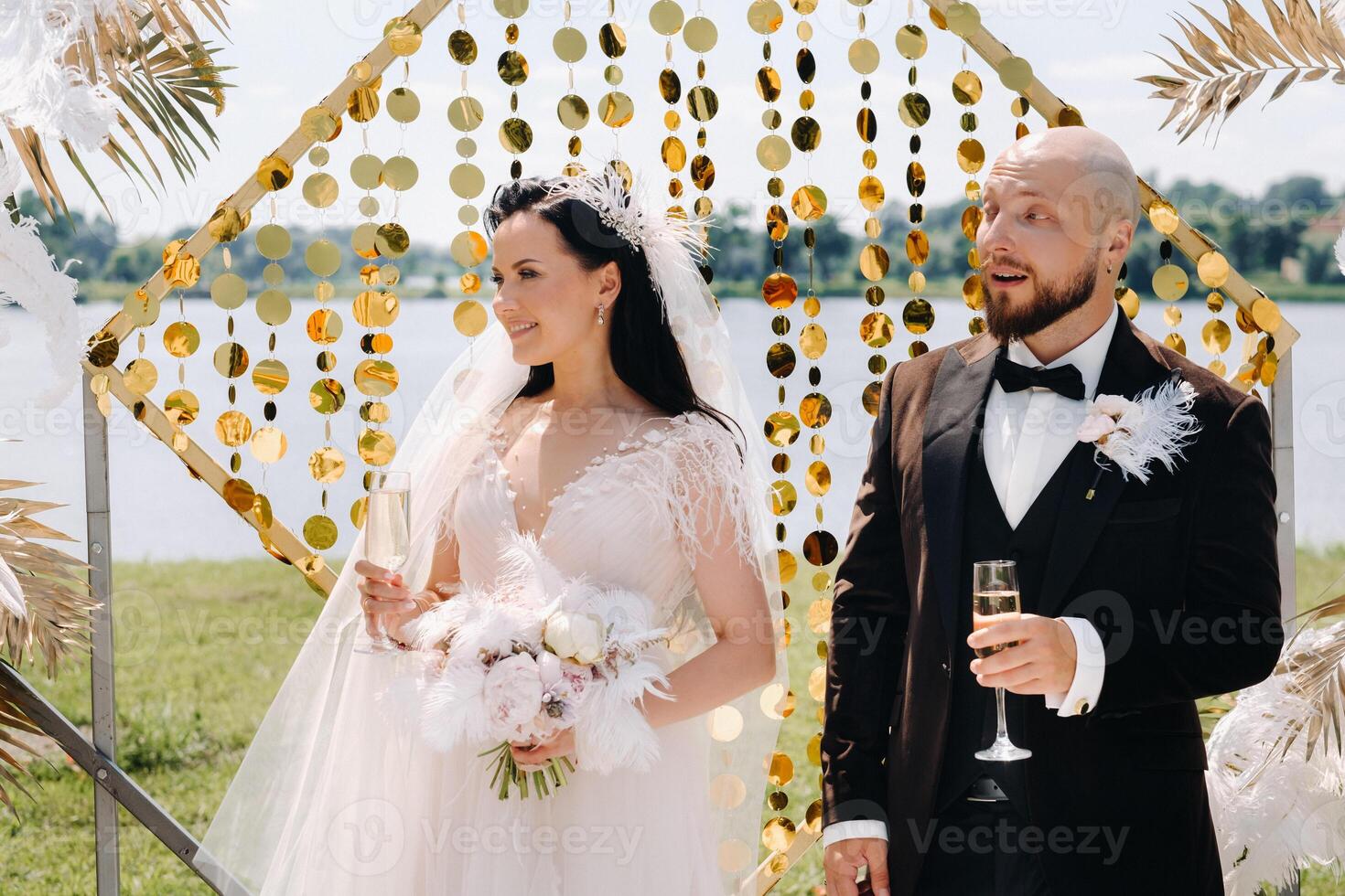happy wedding couple near the wedding arch during the ceremony photo