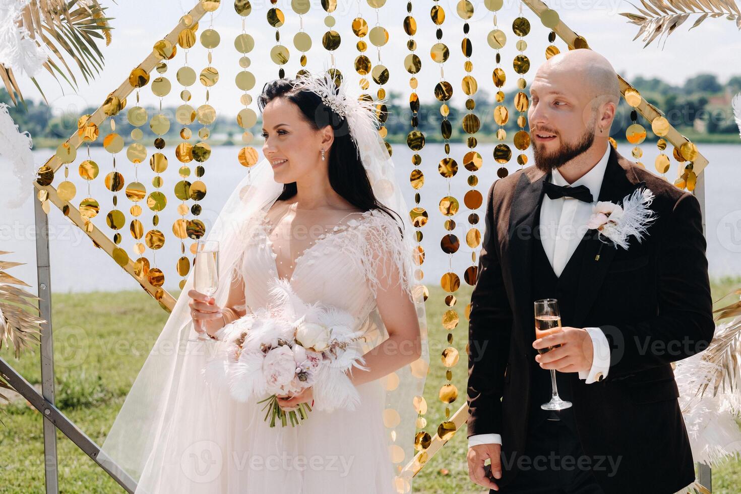 happy wedding couple near the wedding arch during the ceremony photo