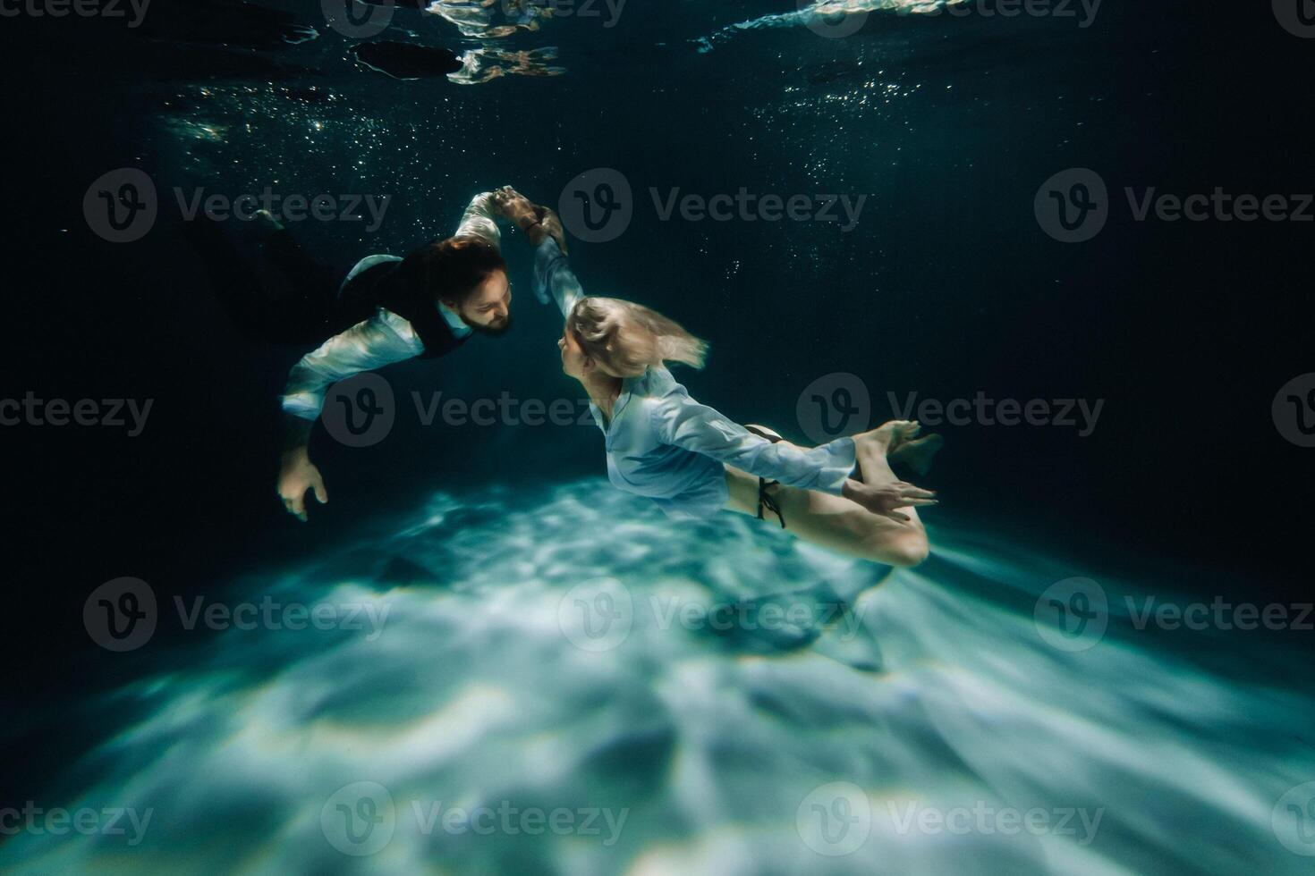 A woman and a man meet under water.A couple of lovers under water photo