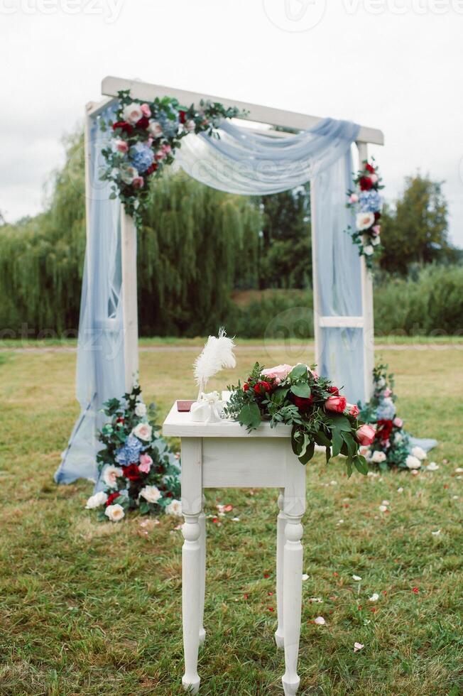 Wedding ceremony on the street on the green lawn.Decor with fresh flowers arches for the ceremony photo
