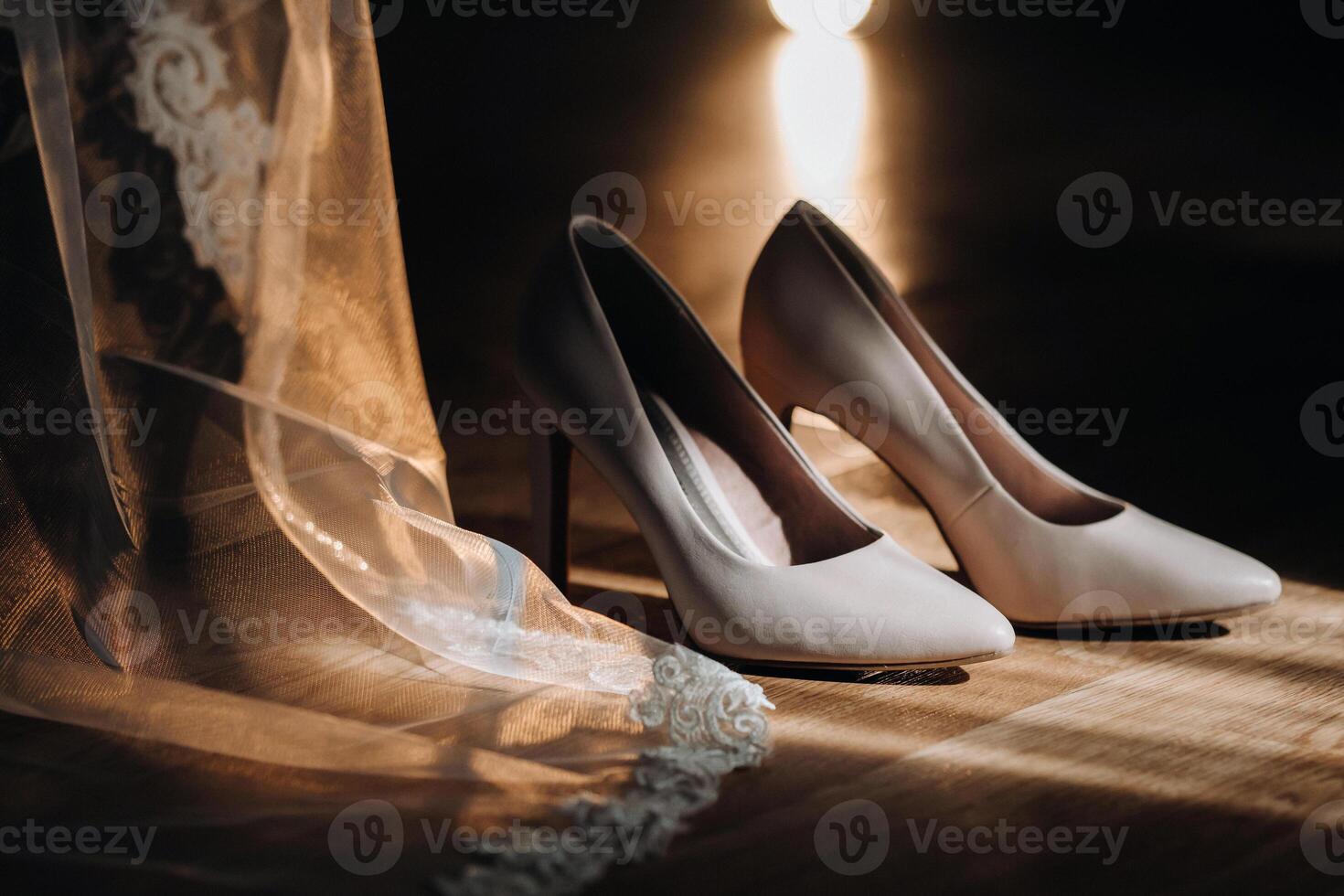 white wedding shoes standing on the field near the dress photo