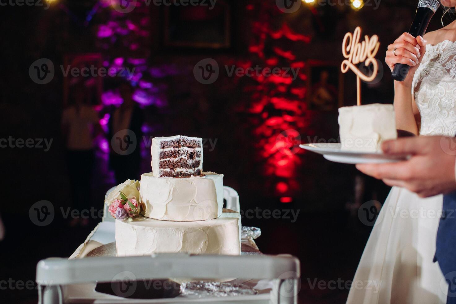 The bride and groom cut their wedding cake. beautiful cake with a cut and visible filling. wedding cake with the word love,the concept of the wedding photo