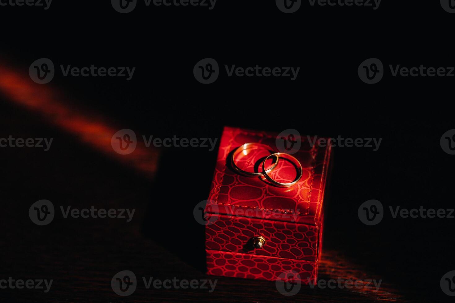 Close-up of two gold wedding rings for the wedding lie on a red box photo