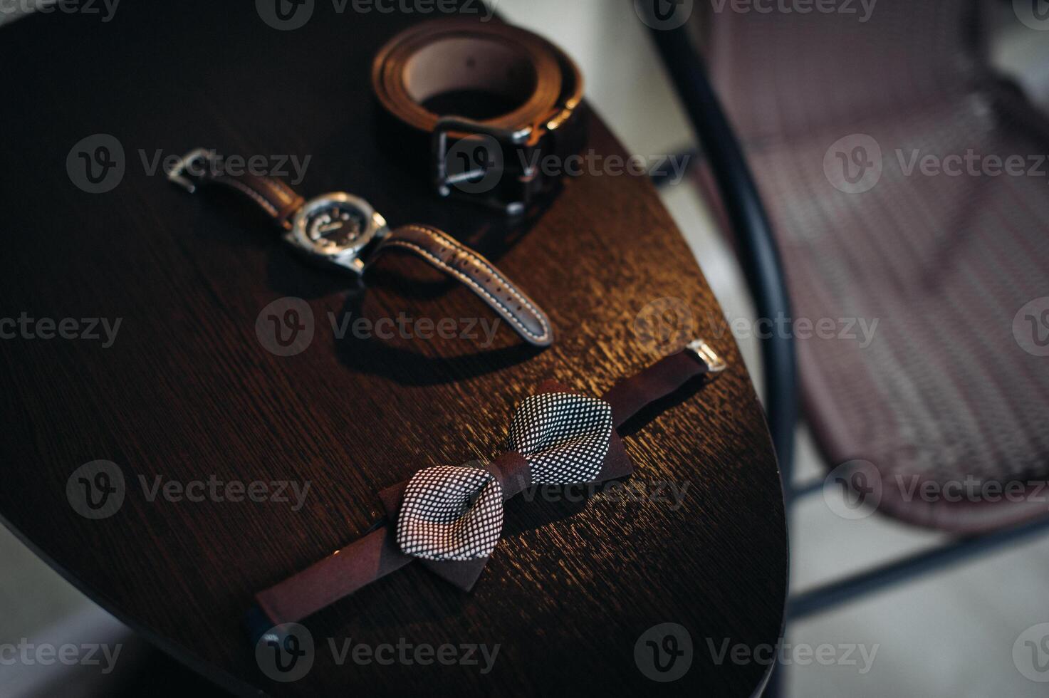 black bow tie on light background and watch photo