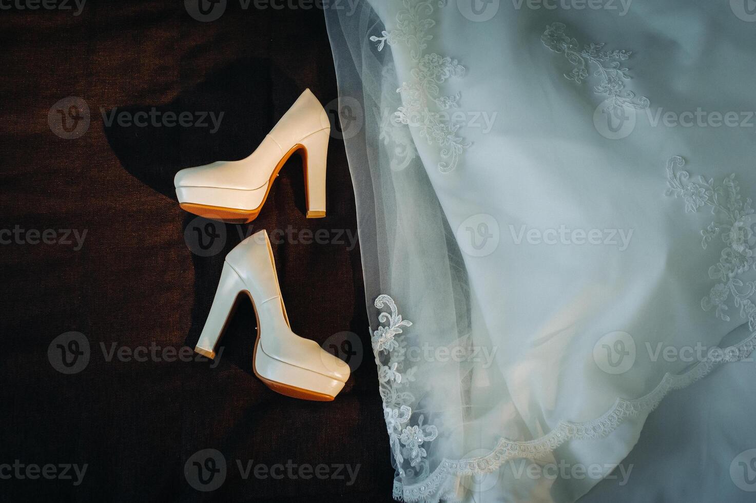 white wedding shoes and dress on black background photo
