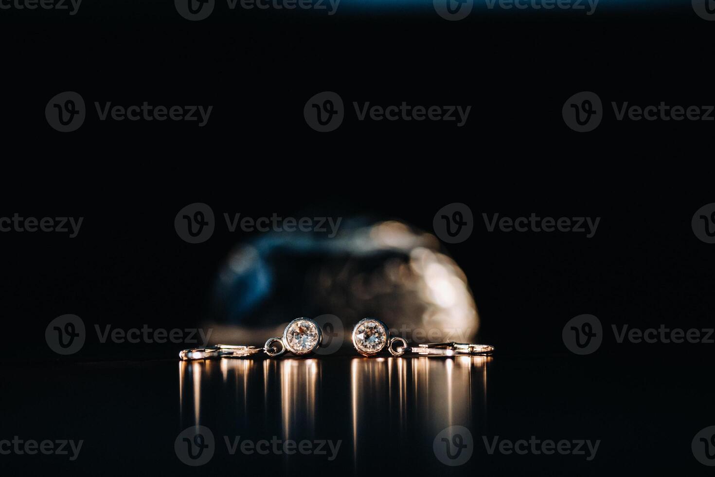 Accessories for the bride. Earrings on a black background. White wedding earrings. Space for text and ads. photo