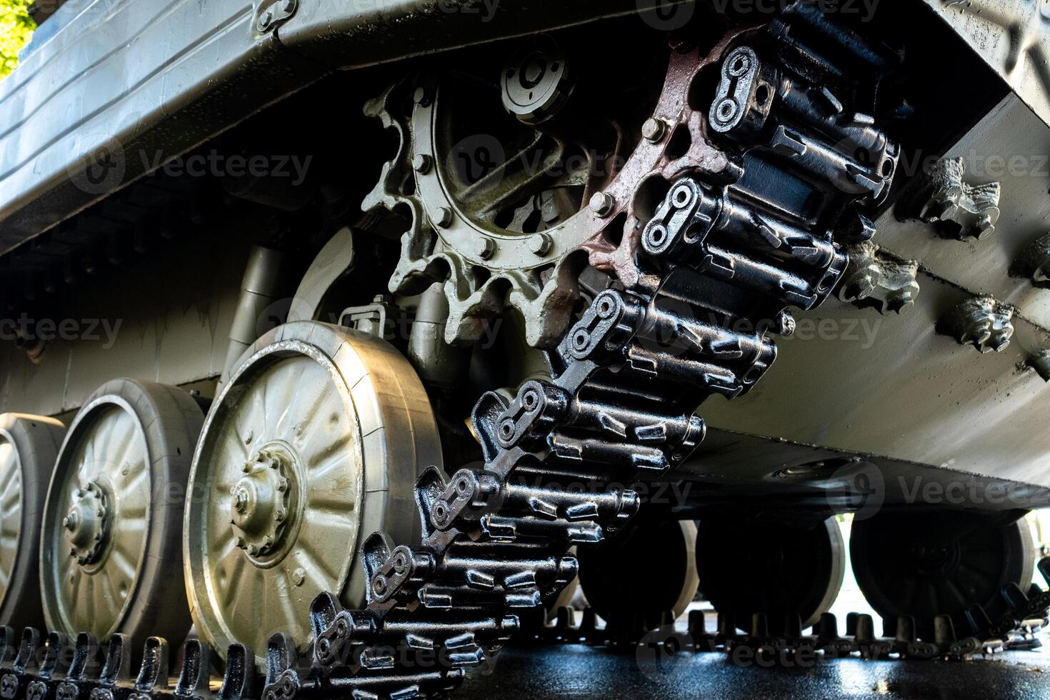 Tracked armor close-up. Black link tracks and large rubberized rollers. Chassis of an infantry fighting vehicle photo