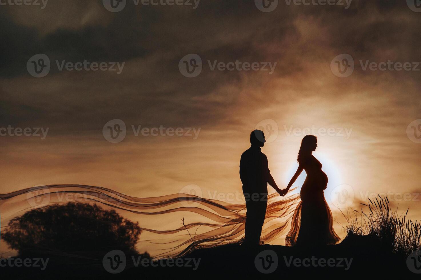 A loving man stands next to a pregnant woman at sunset, in the sand dunes. An unrecognizable Portrait of a beautiful newlywed couple expecting a baby.Lithuania, Nida photo