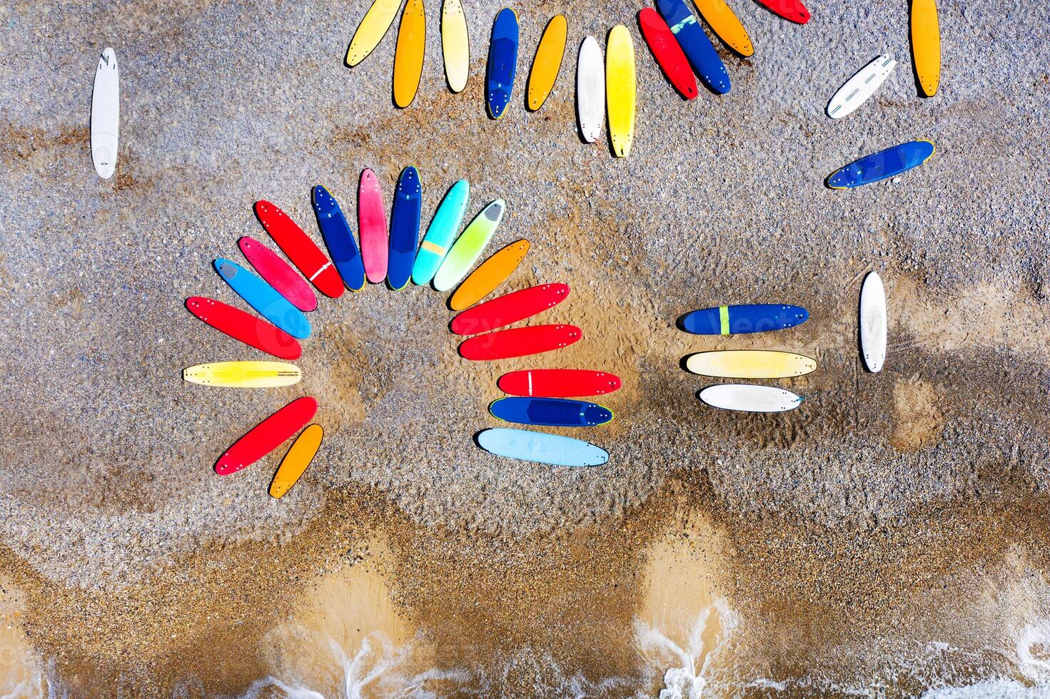 Top view of colored surfboards lying chaotically on a shingle beach in France photo