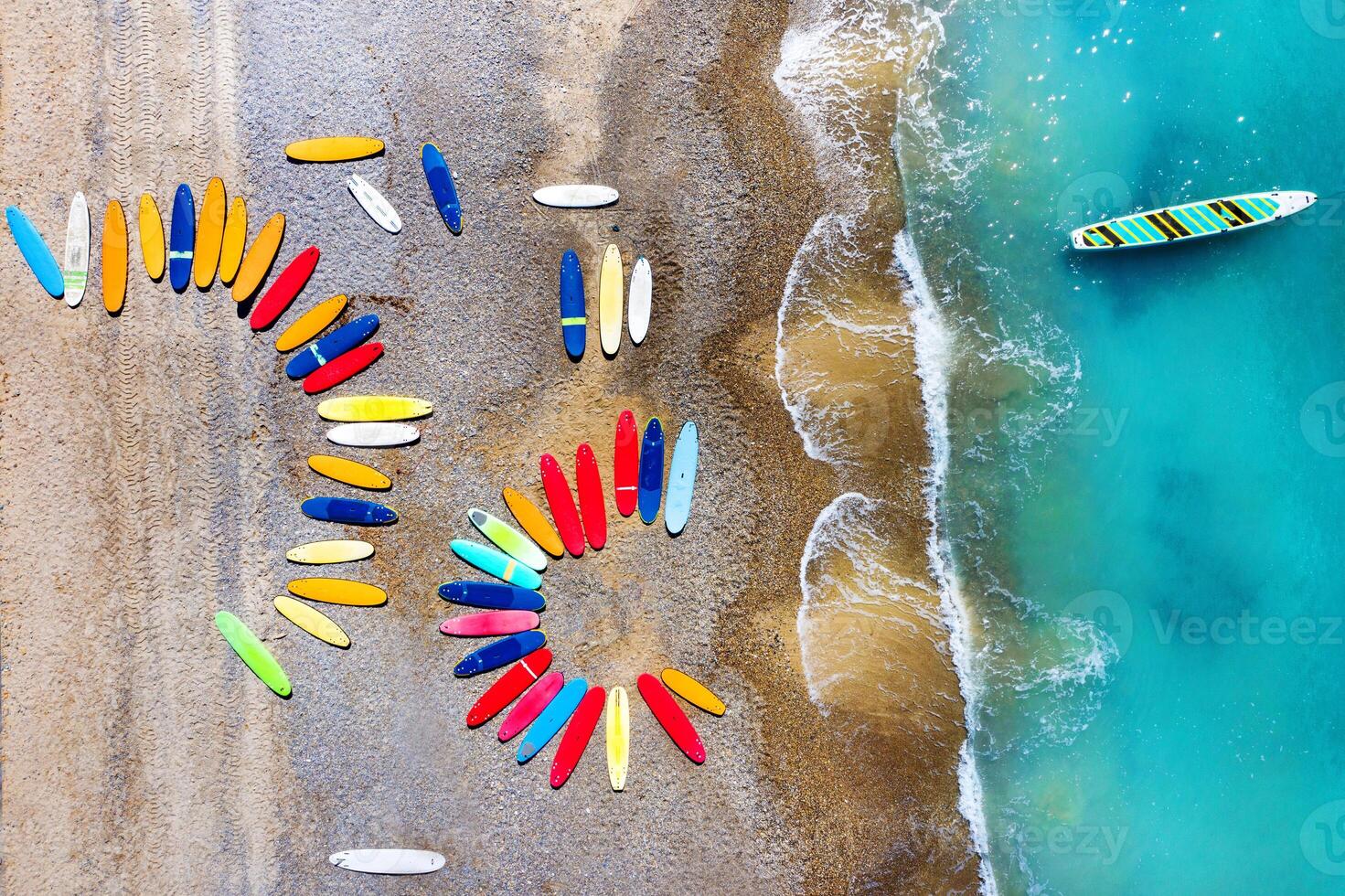 Top view of colored surfboards lying chaotically on a shingle beach in France photo