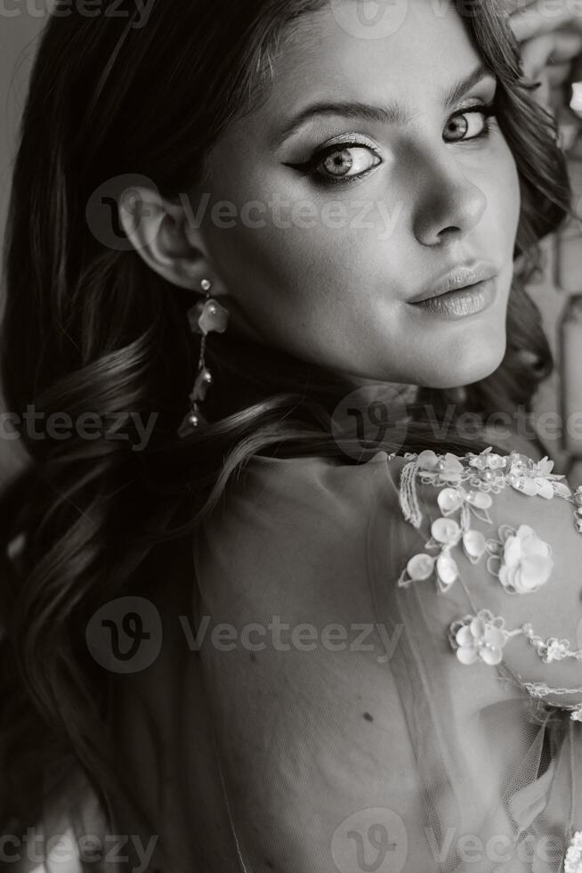 Close-up portrait of a luxurious bride in a wedding dress in the morning in her interior photo