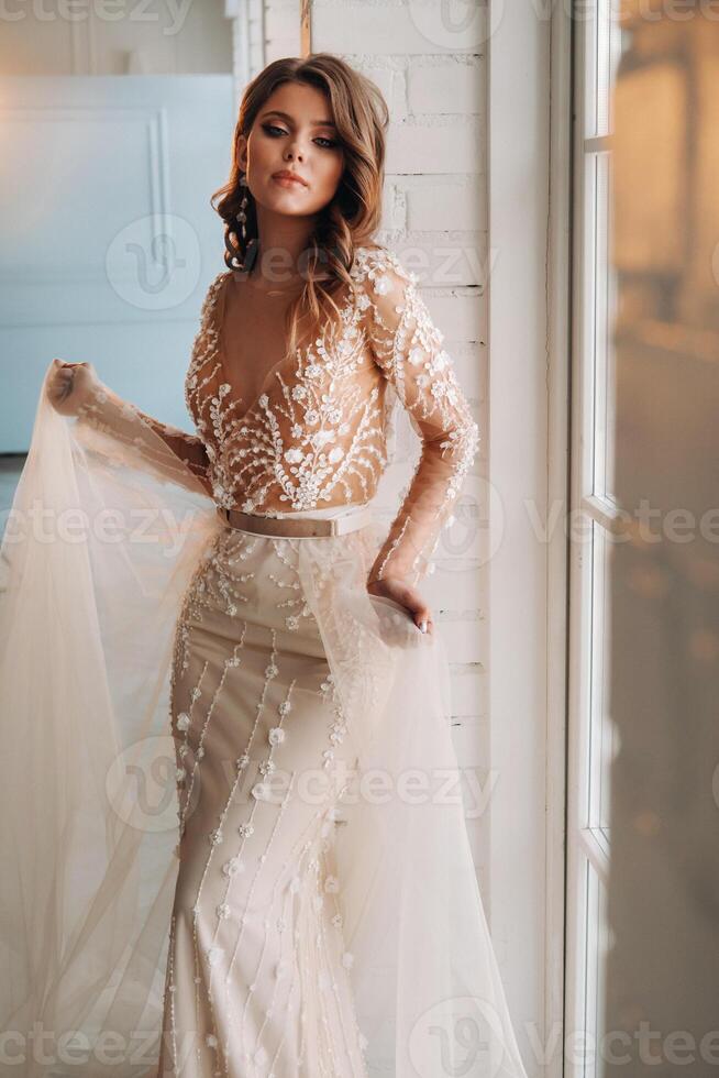 A luxurious bride in a wedding dress in the morning in her interior photo