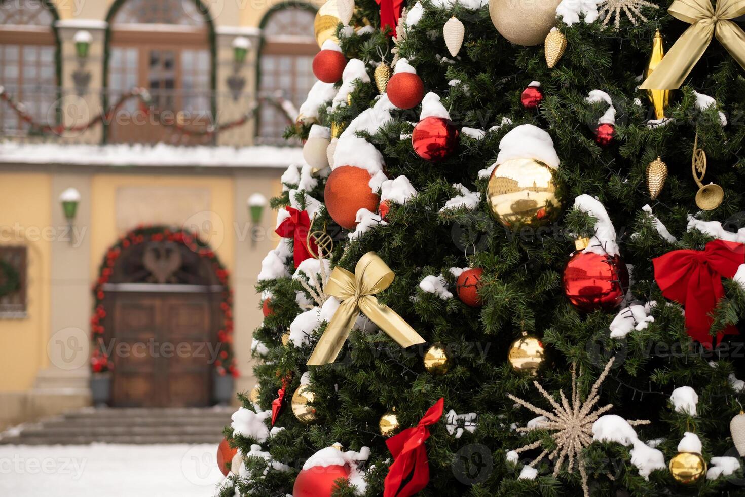 Close-up of a decorated Christmas tree standing outside in the snow photo