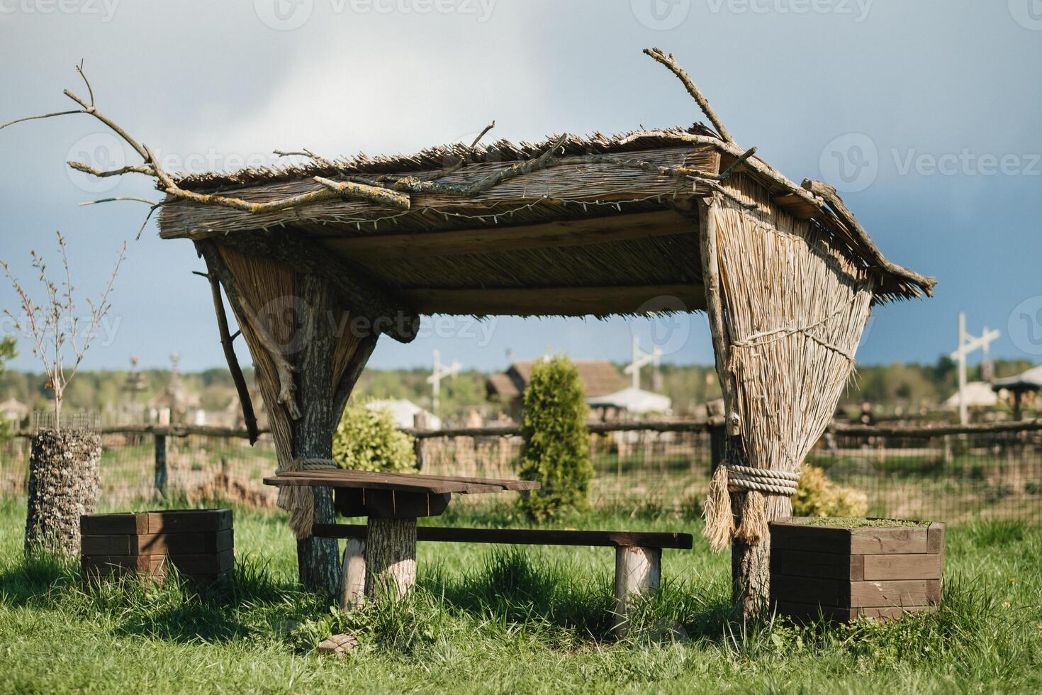 An old wooden gazebo for relaxing in the park. Equipped with wooden tables and benches photo