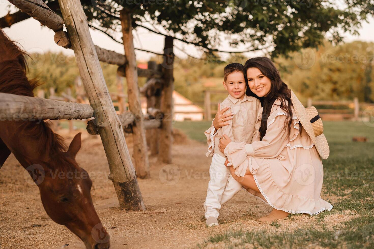 A pregnant woman with her son walks in the countryside in the summer photo