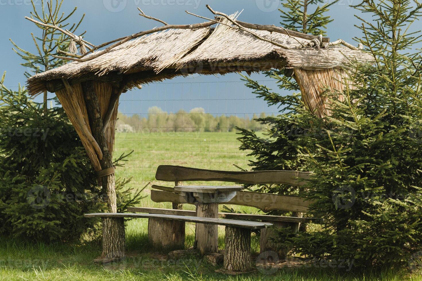An old wooden gazebo for relaxing in the park. Equipped with wooden tables and benches photo