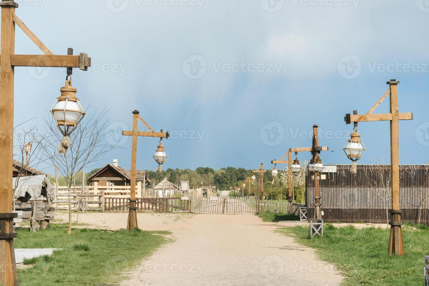 Old wooden lanterns hanging on a wooden pole along the road photo