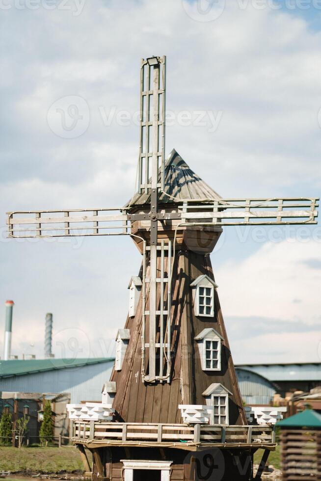 Decorative wooden mill standing outside in summer photo