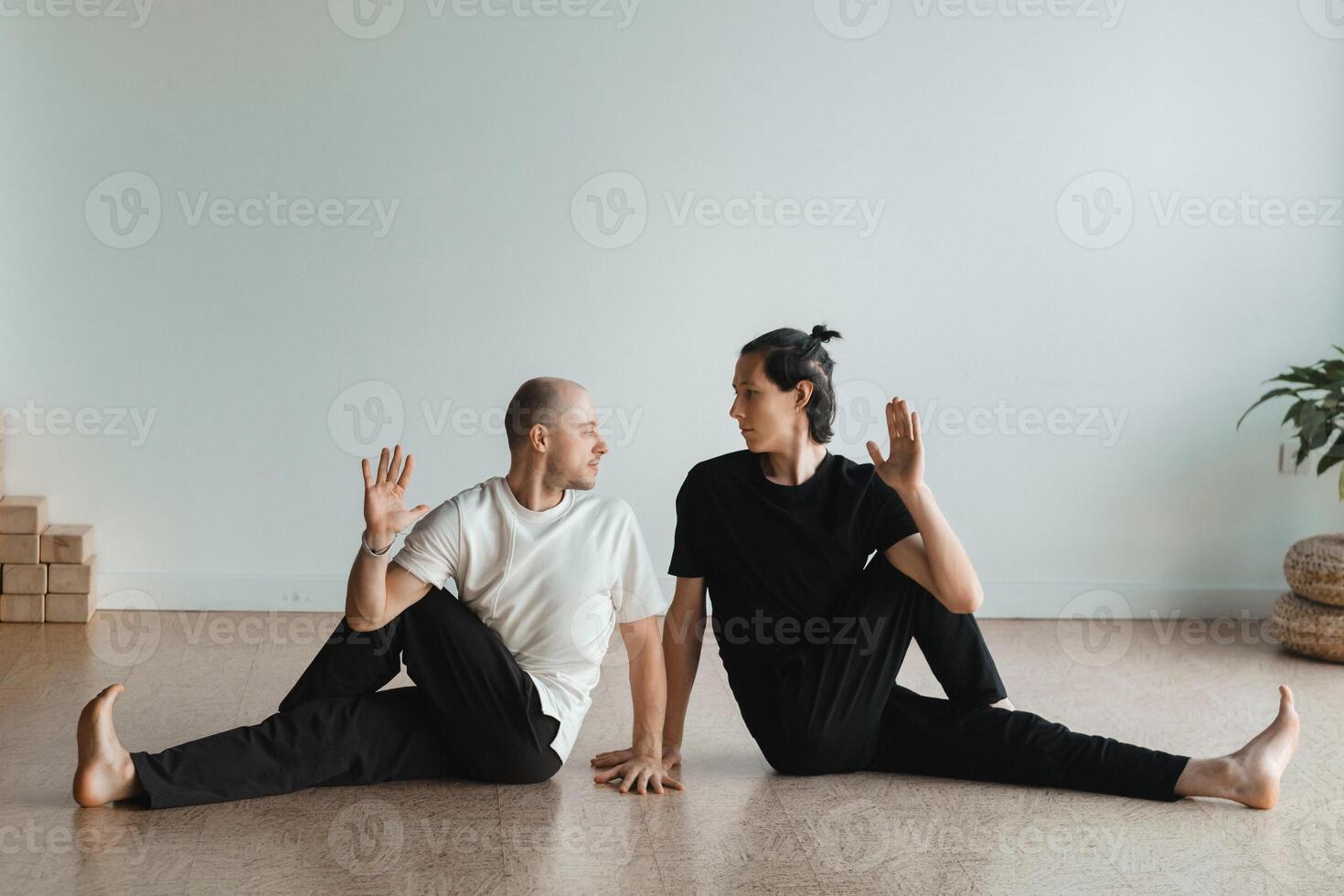 two young athletes practice yoga in the gym. Joint training, indoors, studio. The concept of a healthy lifestyle photo