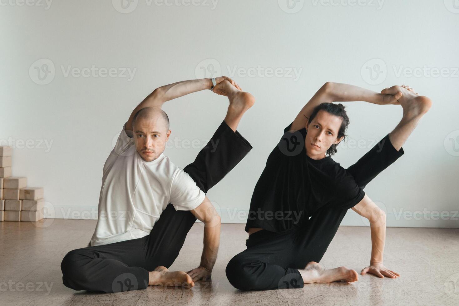 two young athletes practice yoga in the gym. Joint training, indoors, studio. The concept of a healthy lifestyle photo