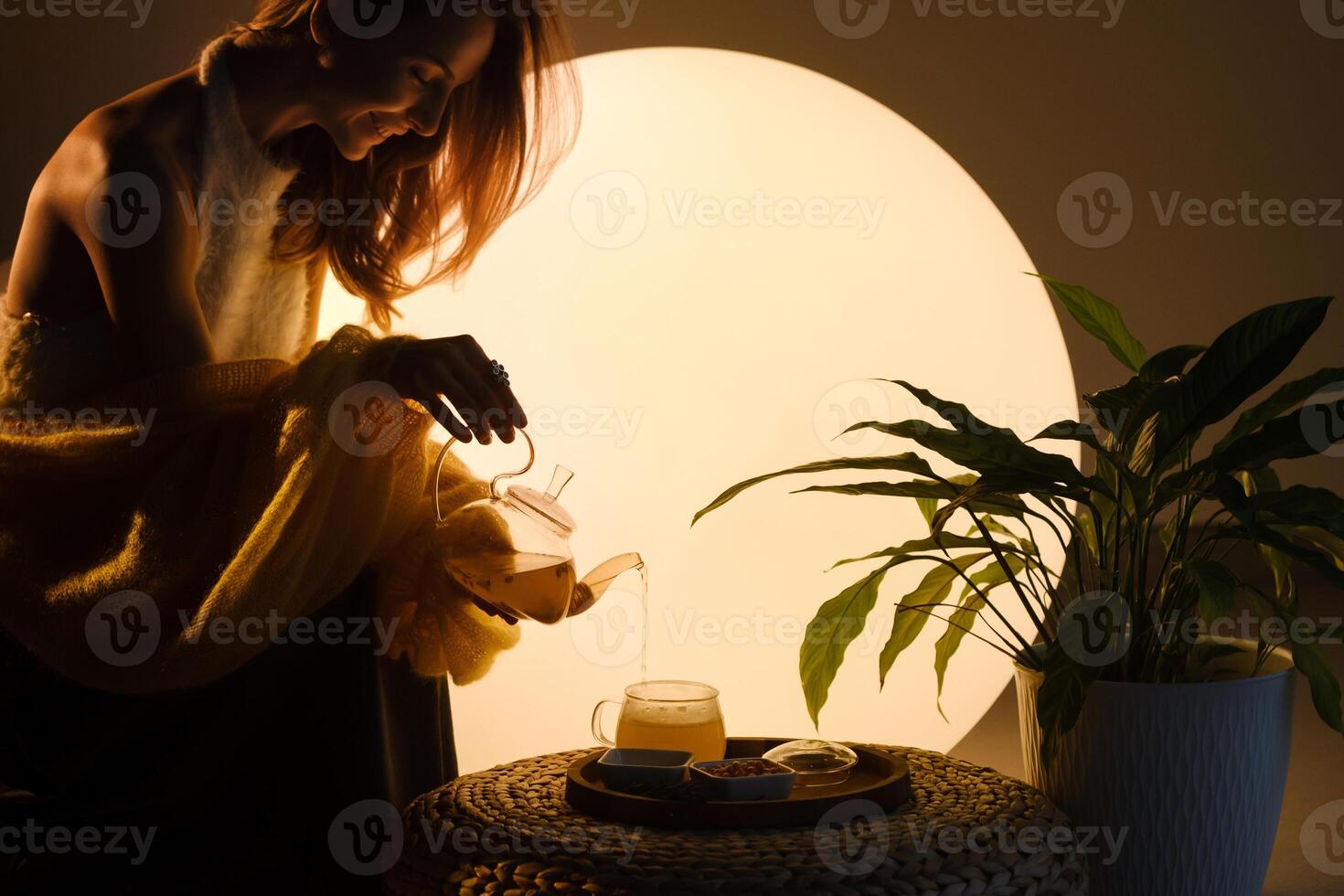 A young girl conducts an evening tea drinking procedure indoors. Relaxing tea party photo