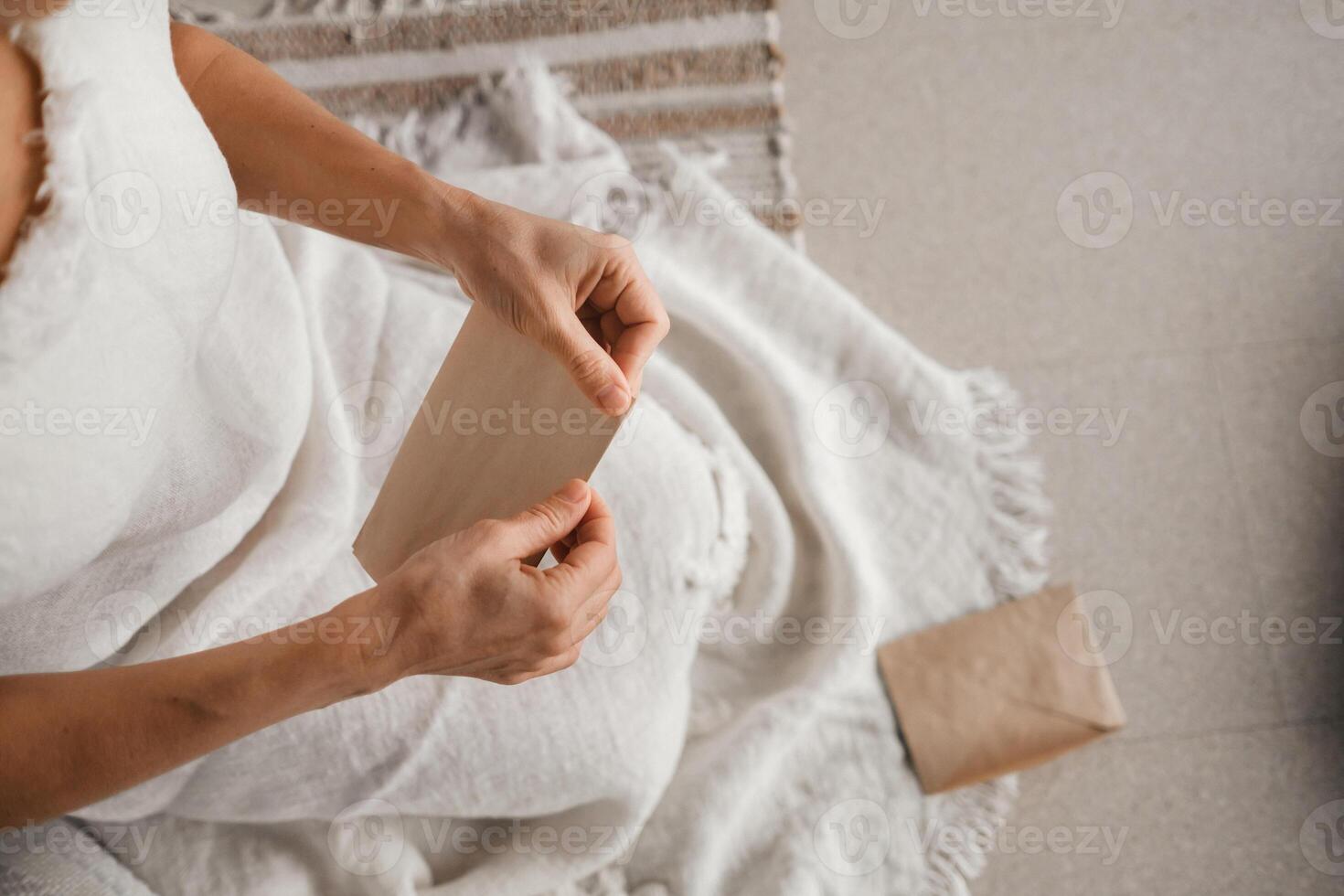 A woman in white clothes holds an envelope with a wish in her hands. The concept of a women's circle photo