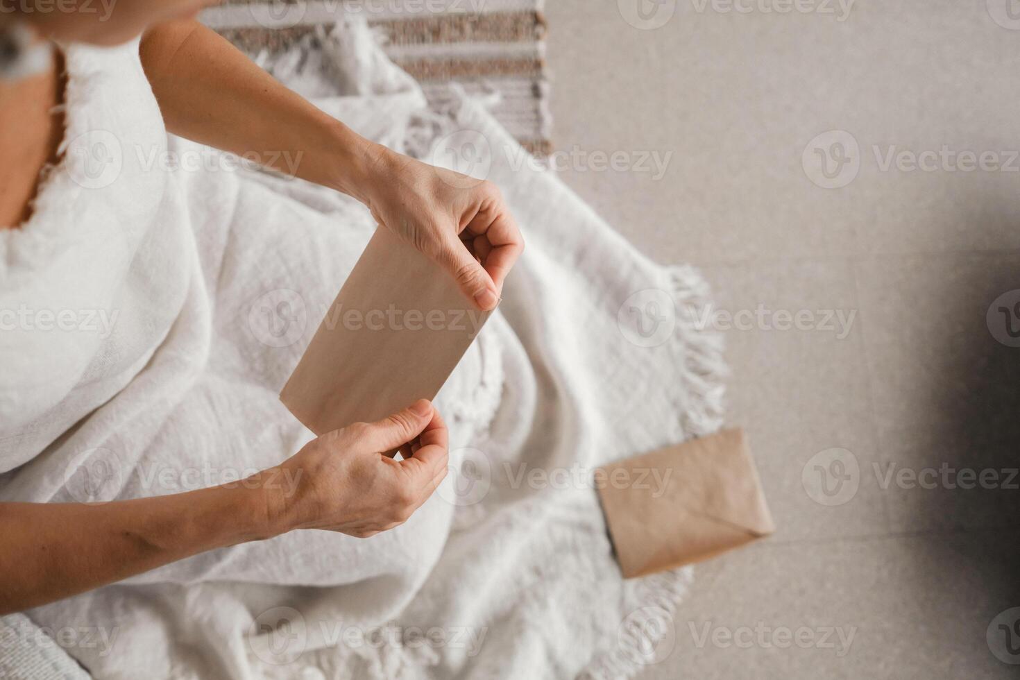 A woman in white clothes holds an envelope with a wish in her hands. The concept of a women's circle photo