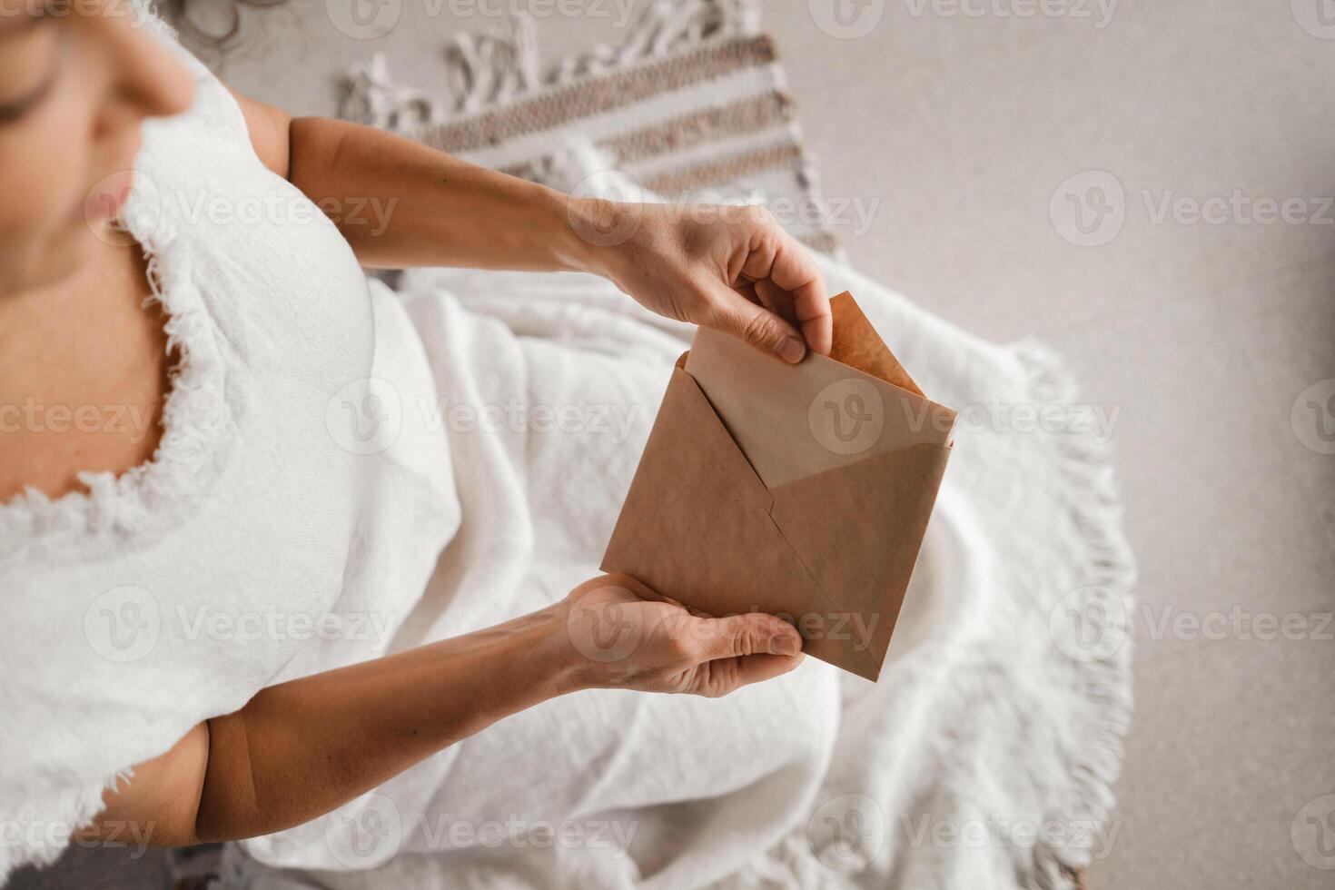 A woman in white clothes holds an envelope with a wish in her hands. The concept of a women's circle photo