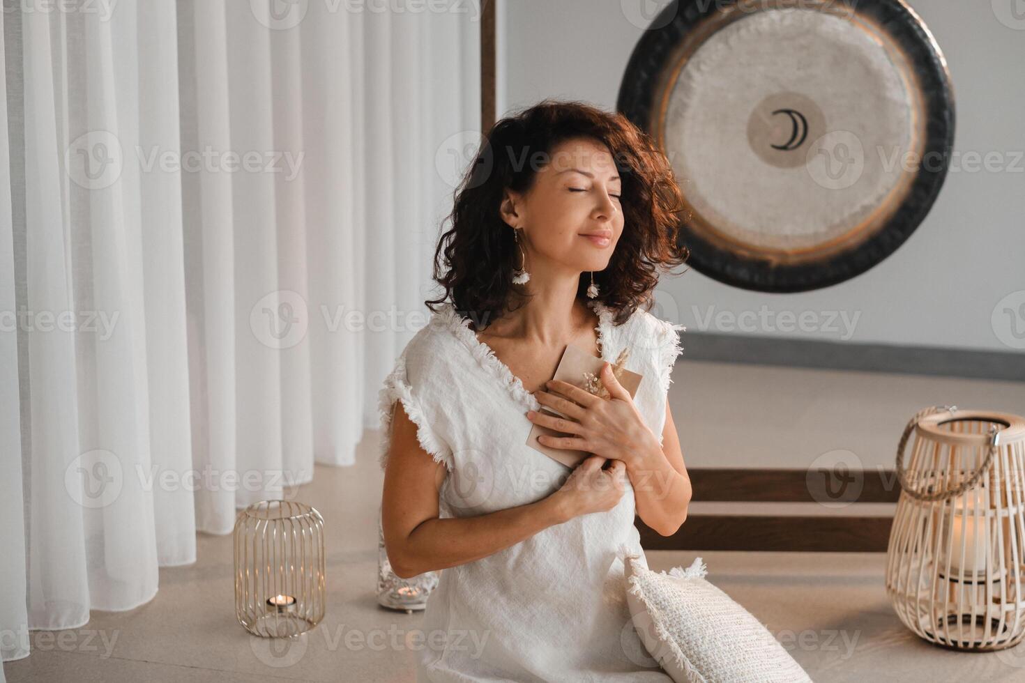 A woman in white clothes holds an envelope with a wish in her hands. The concept of a women's circle photo