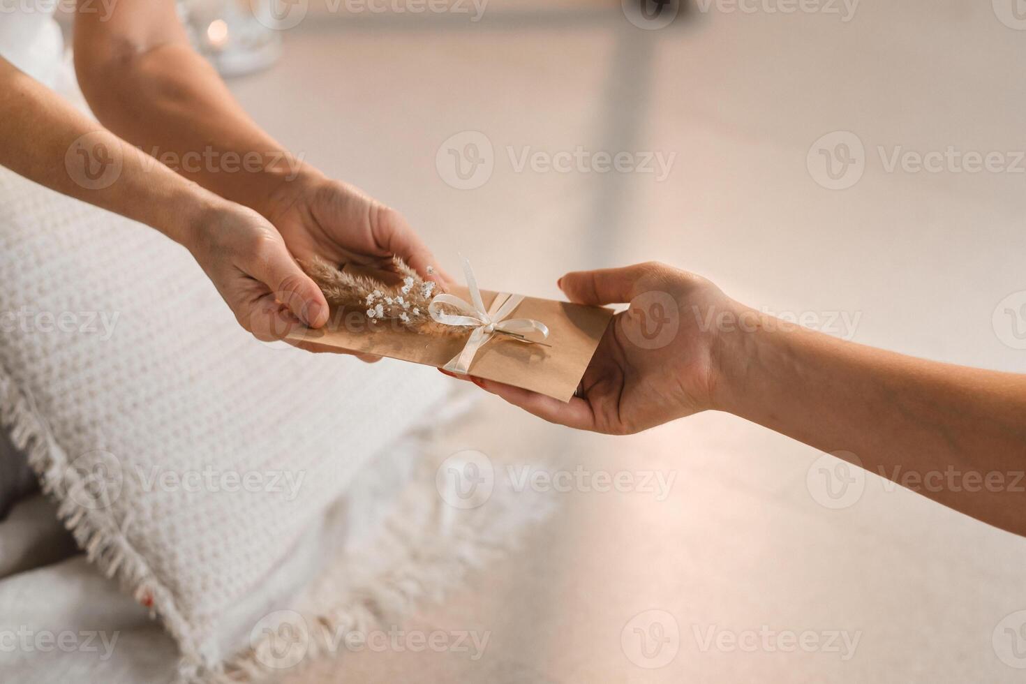 A woman in white clothes passes an envelope with a wish to another woman. The concept of the women's circle photo