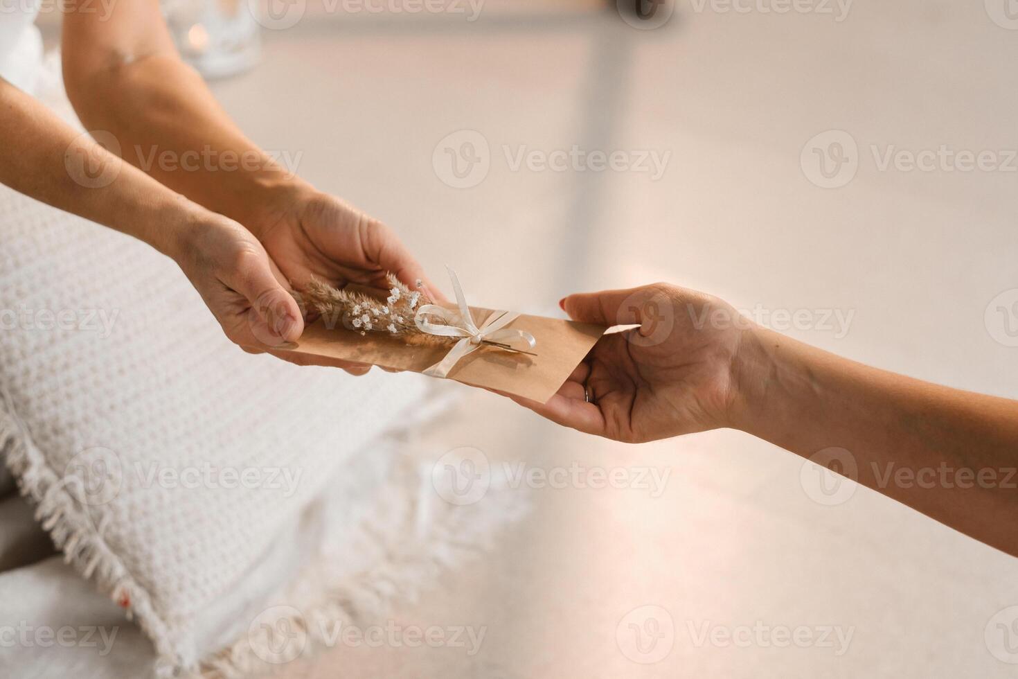 A woman in white clothes passes an envelope with a wish to another woman. The concept of the women's circle photo