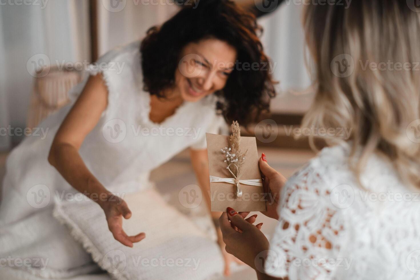 A woman in white clothes passes an envelope with a wish to another woman. The concept of the women's circle photo