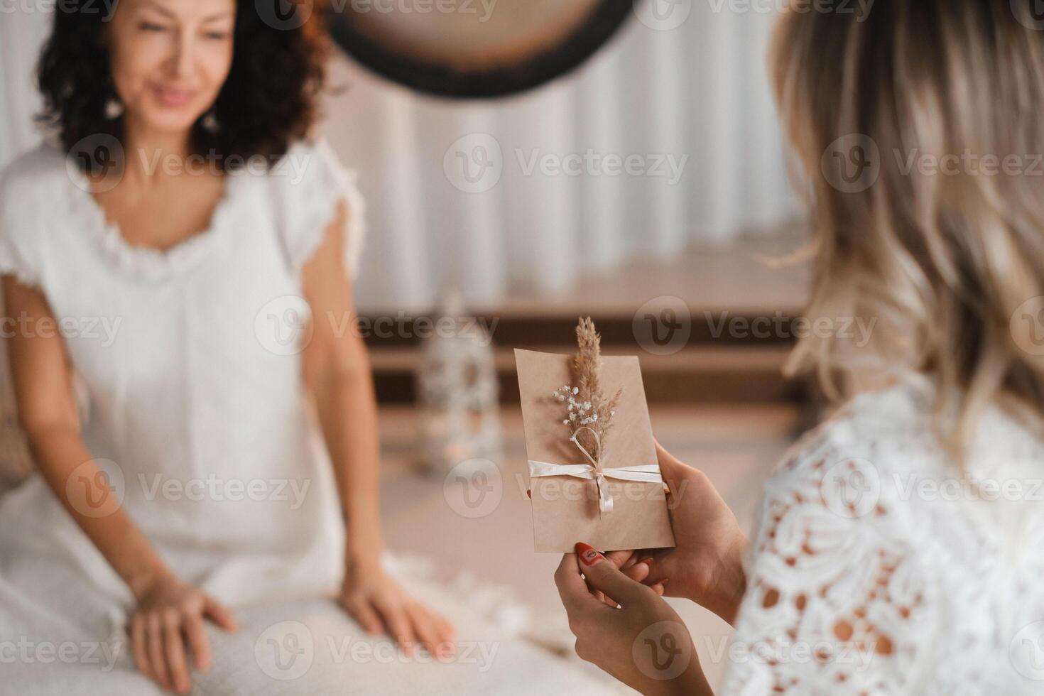 A woman in white clothes holds an envelope with a wish in her hands. The concept of a women's circle photo
