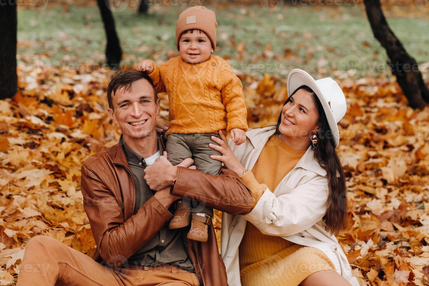 Father and mother with son walking in the autumn Park. A family walks in the Golden autumn in a nature Park. photo