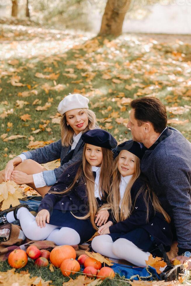 A big family on a picnic in the fall in a nature park. Happy people in the autumn park photo
