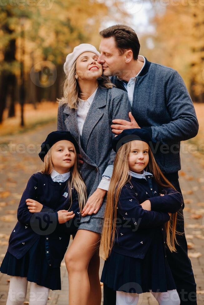A large family walks in the park in the fall. Happy people in the autumn park photo