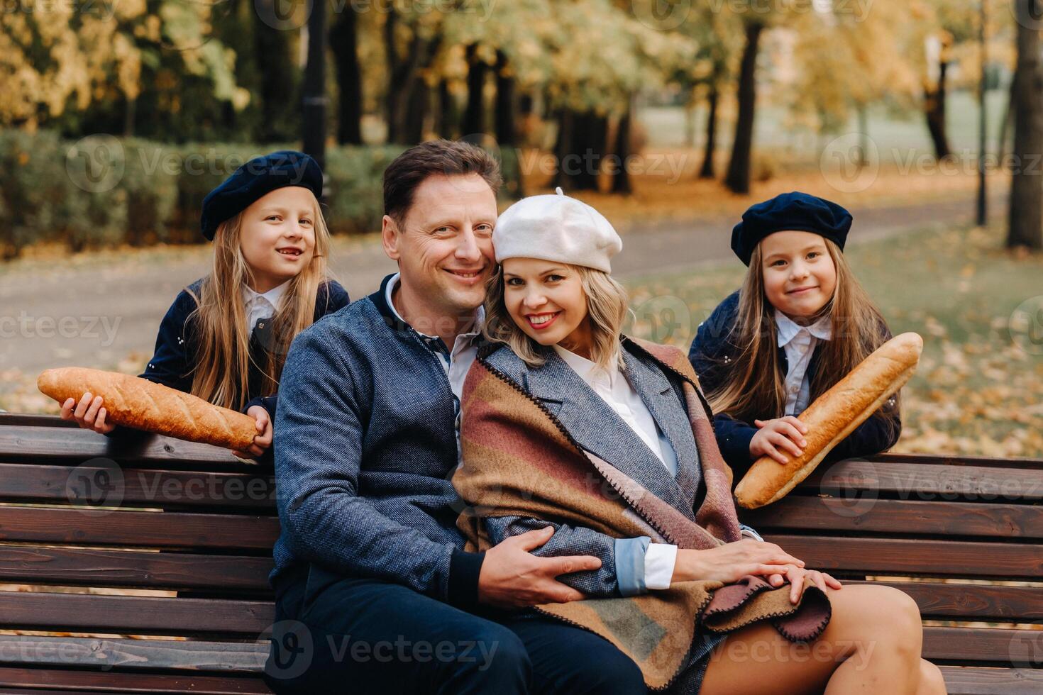 A large family is sitting on a bench in an autumn park. Happy people in the autumn park photo