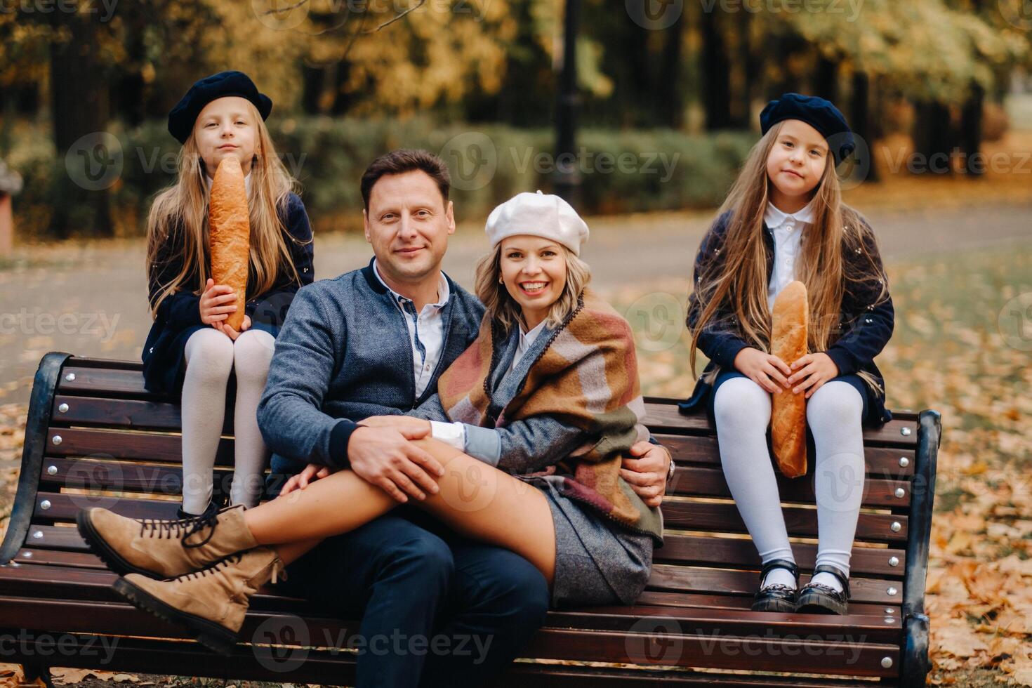 A large family is sitting on a bench in an autumn park. Happy people in the autumn park photo