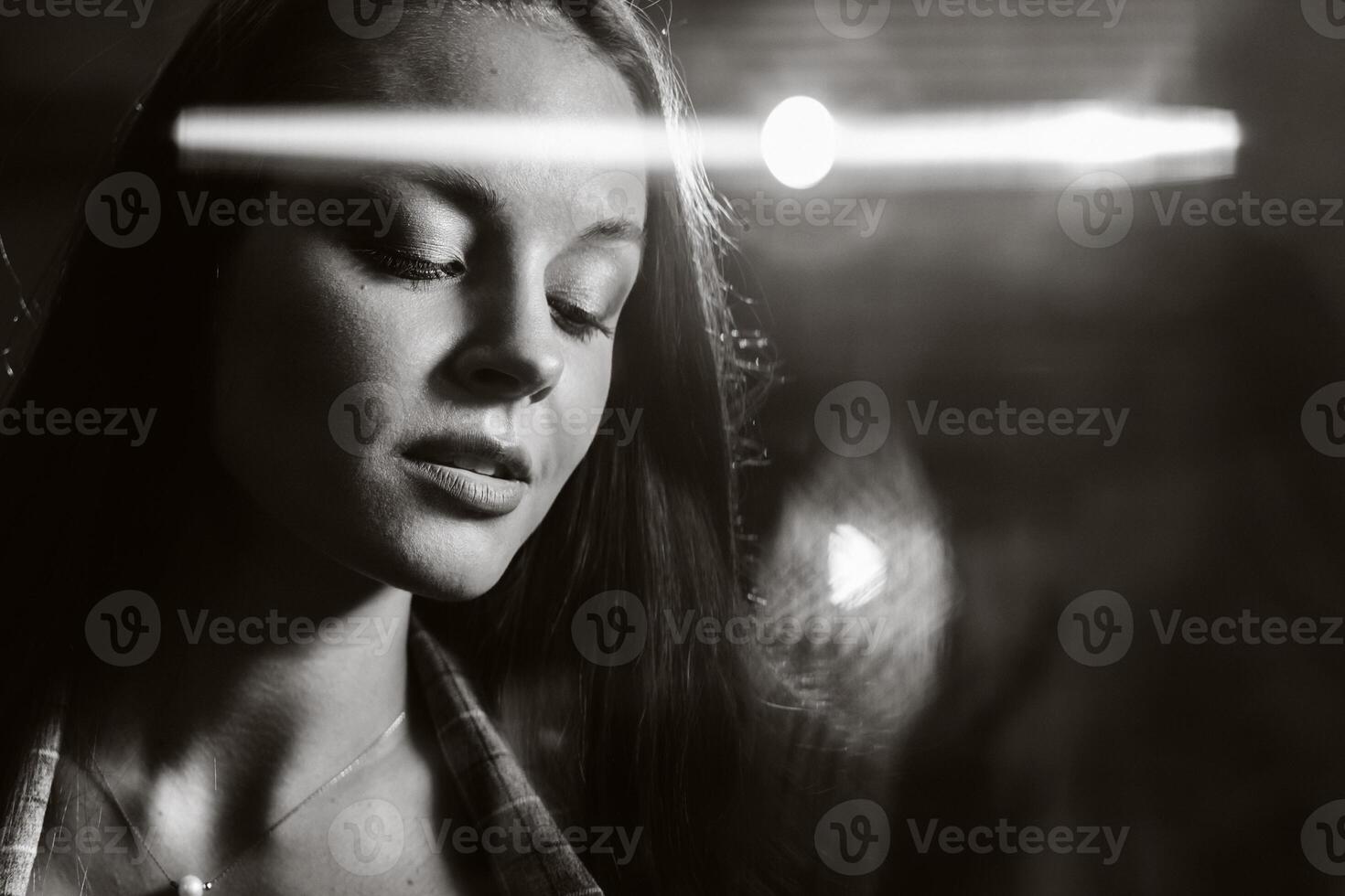 Portrait of a young European girl with long hair in a coffee shop in the evening light, a tall Girl in a jacket with long hair in a cafe. black and white photo