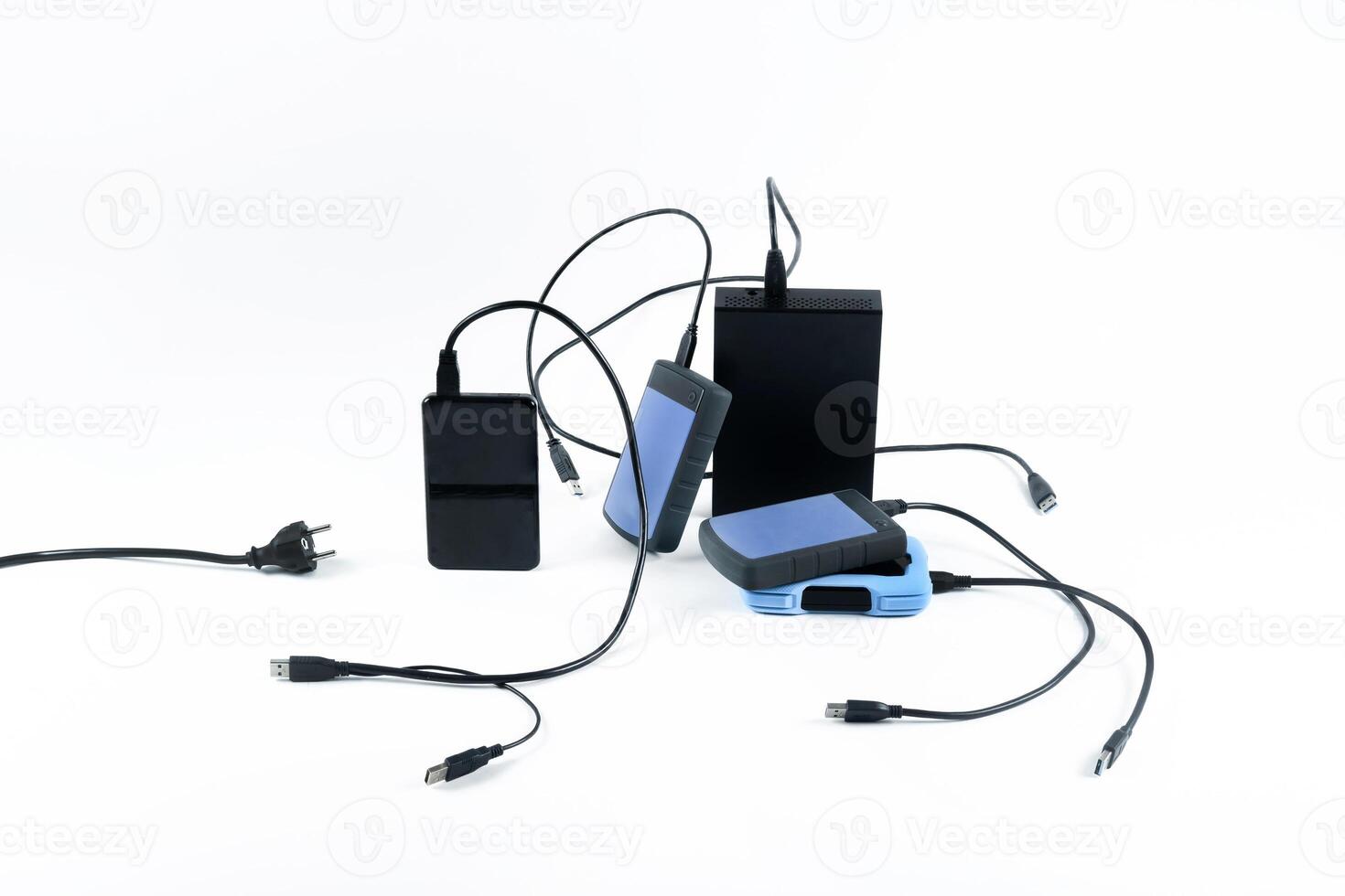 many external hard drives with wires lie on a white background. Hard drives on isolate. photo
