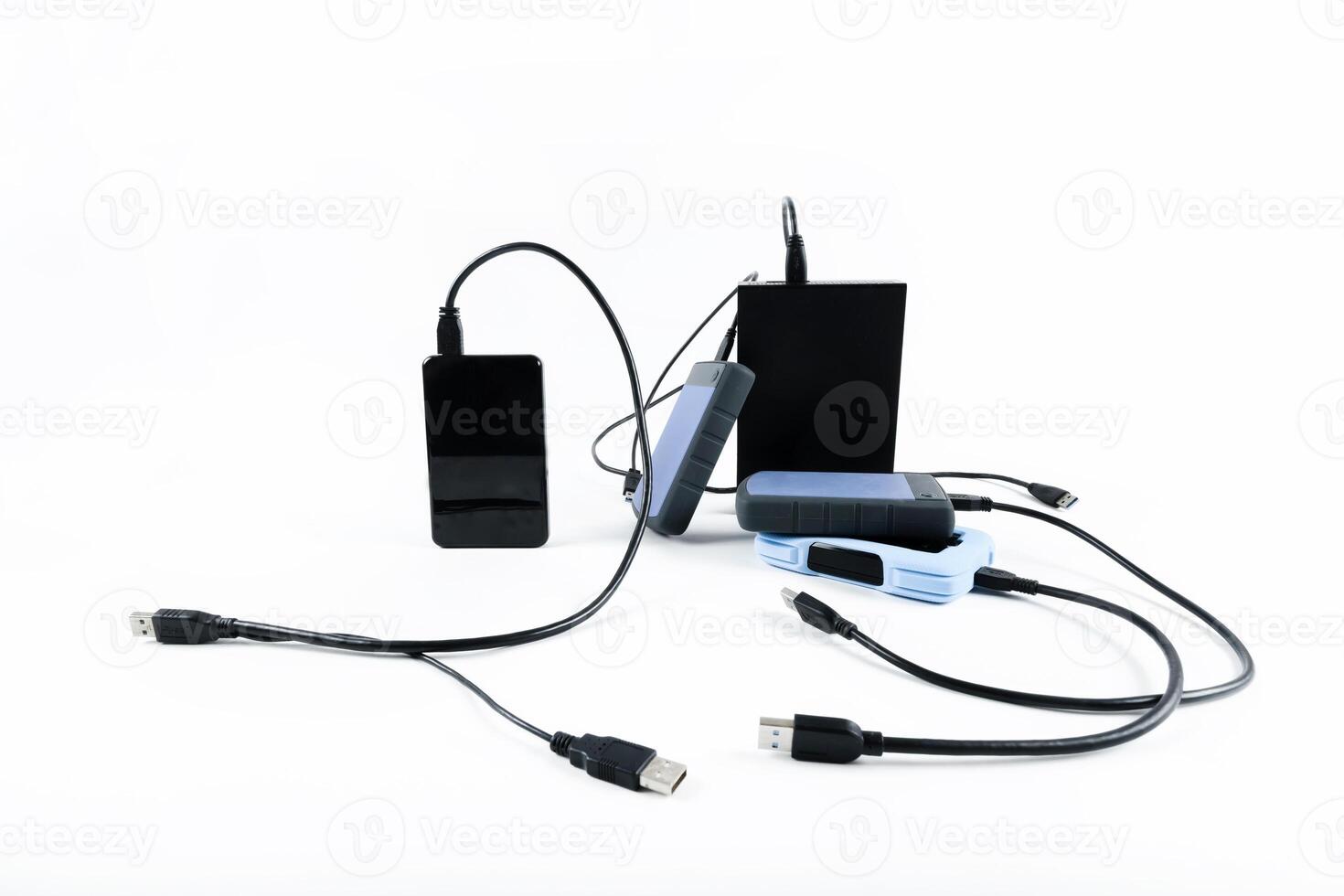 many external hard drives with wires lie on a white background. Hard drives on isolate. photo