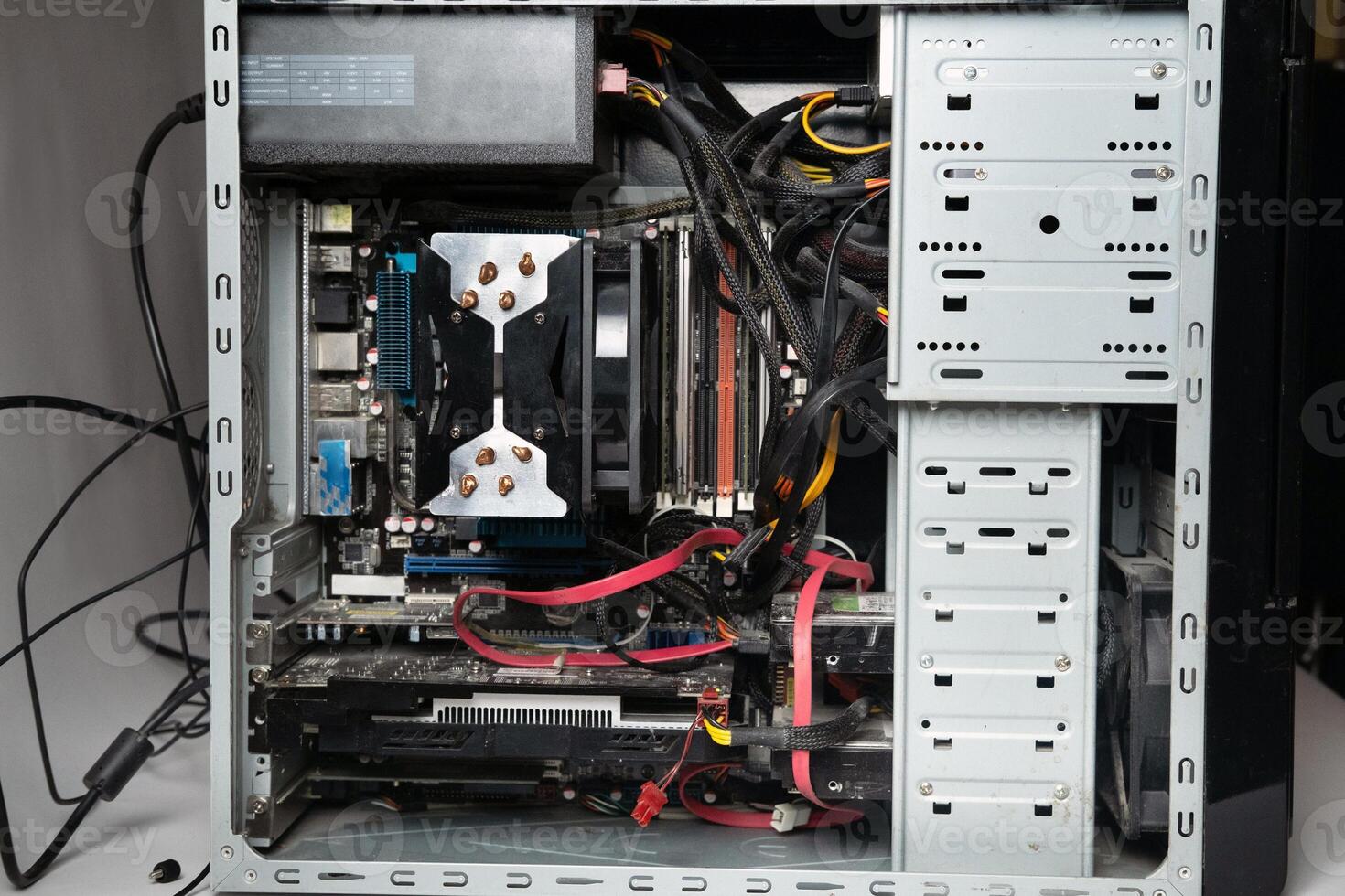 The system unit of the computer is disassembled without a cover.Lots of old computer parts. computer from the inside photo