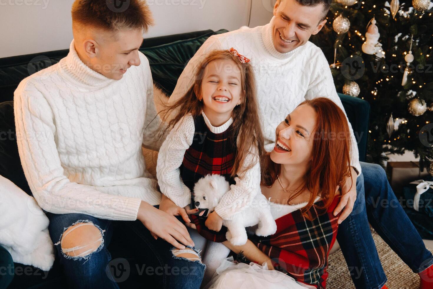 Close-up portrait of a happy family sitting on a sofa near a Christmas tree celebrating a holiday photo