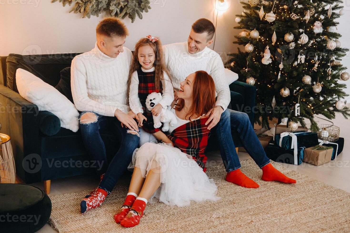 Close-up portrait of a happy family sitting on a sofa near a Christmas tree celebrating a holiday photo