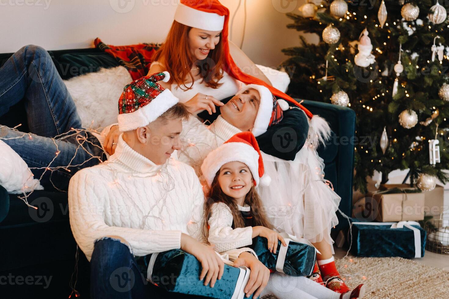 Close-up portrait of a happy family sitting on a sofa near a Christmas tree celebrating a holiday photo