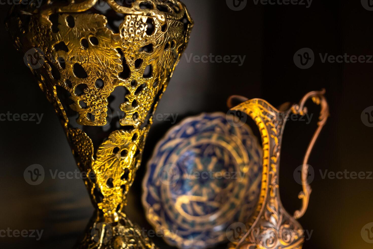 Old copper jug from the east on a black background photo