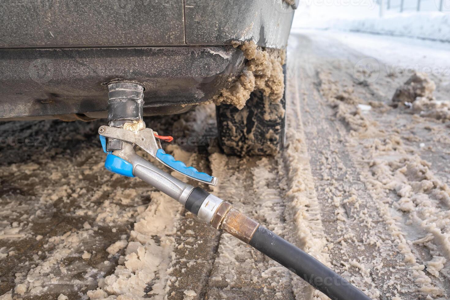 Filling the car from the bottom of the bumper with gas in the winter at the gas station photo