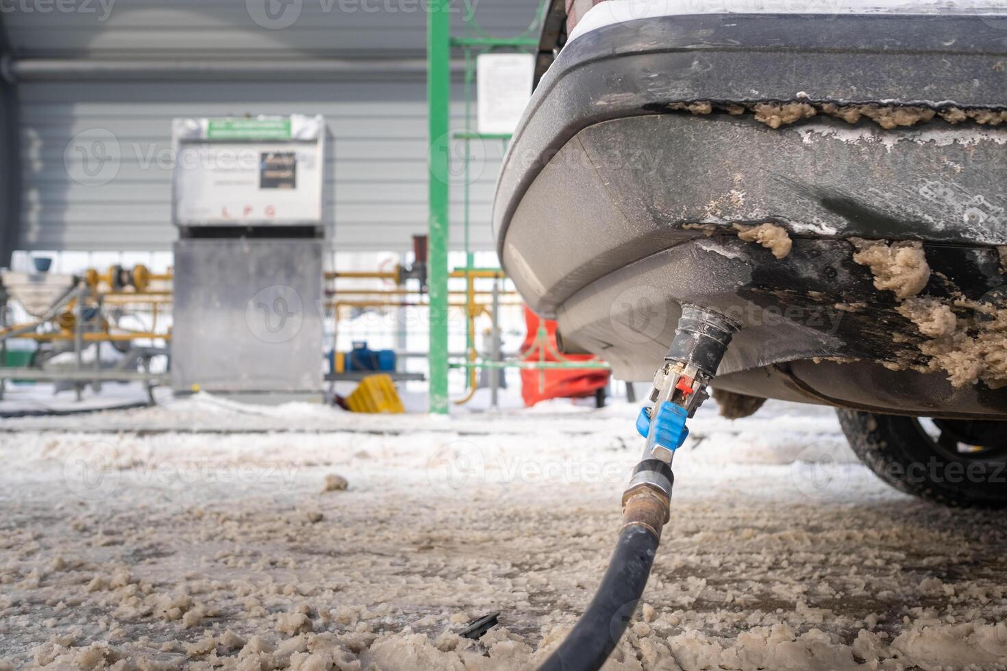 Filling the car from the bottom of the bumper with gas in the winter at the gas station photo