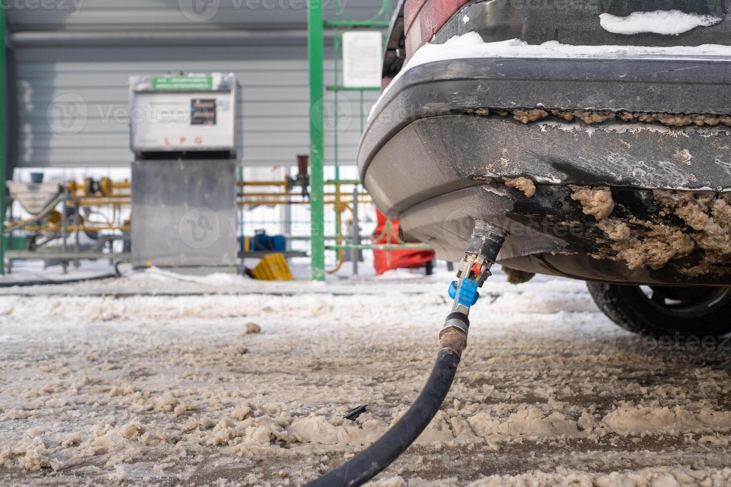 Filling the car from the bottom of the bumper with gas in the winter at the gas station photo